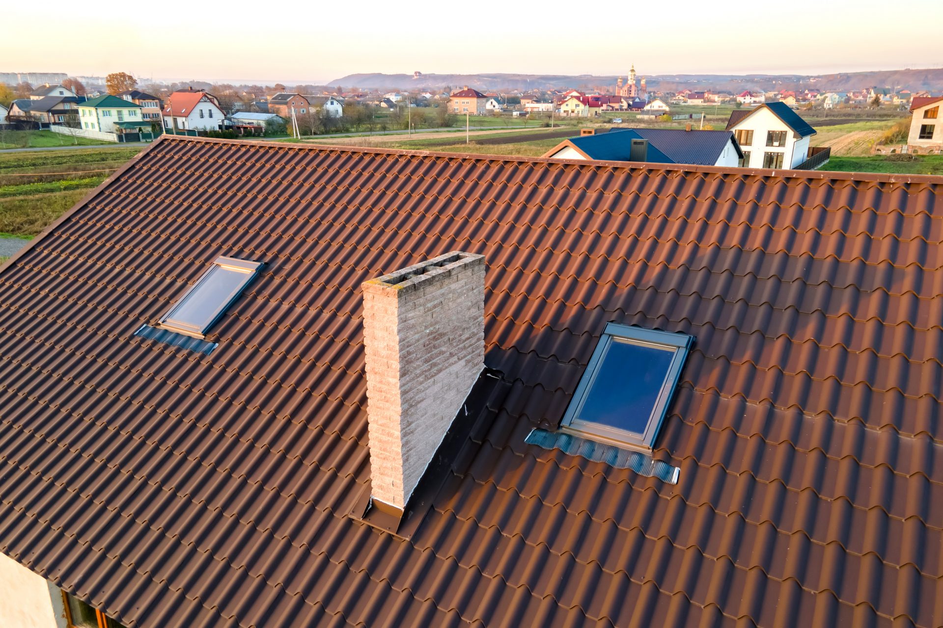 closeup-of-house-brick-roof-with-yellow-shingles-cover-and-attic-glass-windows